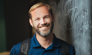 male student standing in front of chalkboard