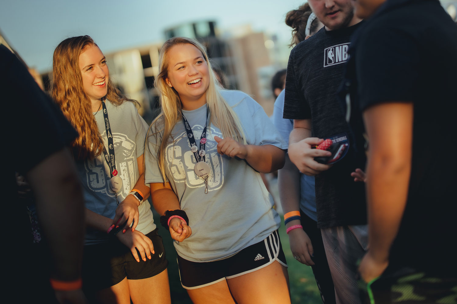 students laughing in group at sunset