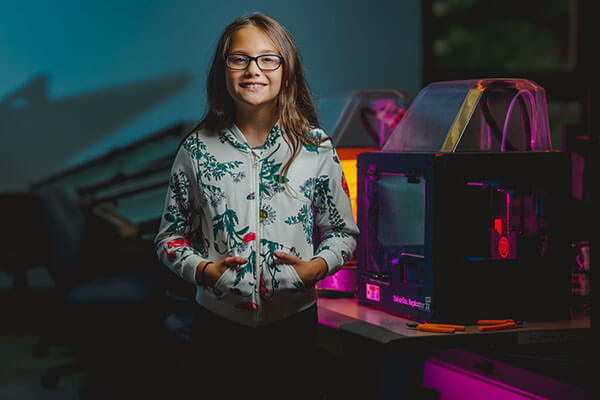 Middle School student in front of 3D Printer