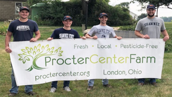 Students posing with banner