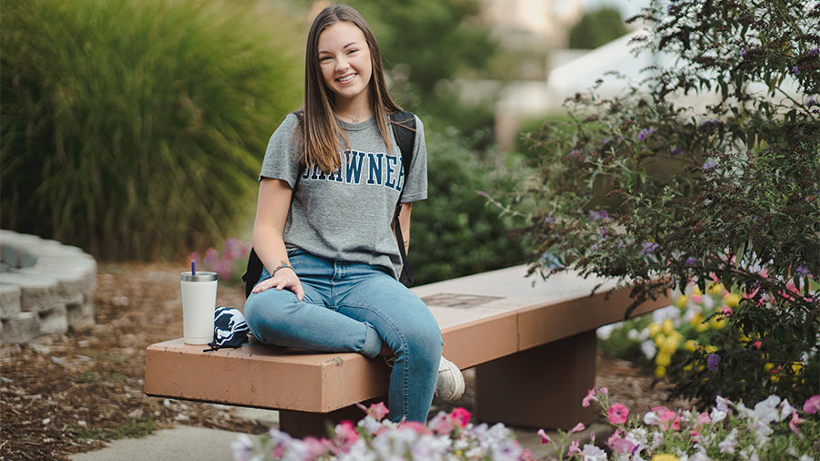 SSU student sitting outside on a bench by fountain