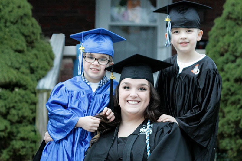 Woman with two boys in graduation regalia