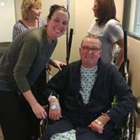 woman smiling beside man in wheelchair smiling