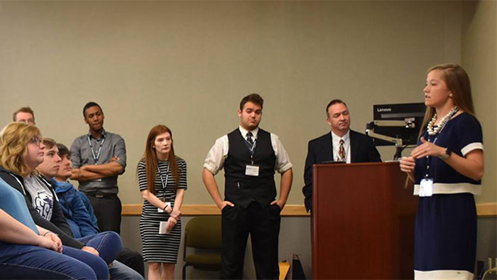 Female giving presentation to a group of students