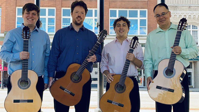 picture of 4 men holding guitars