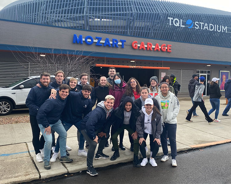 group of students posing in front of stadium