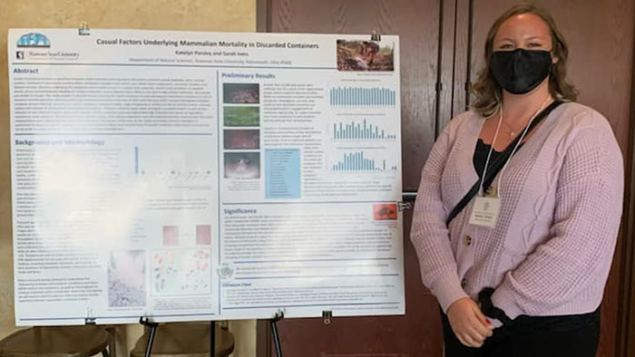 Katelyn Parsley standing beside poster