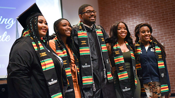 students posing for photo at Donning of the Kente Graduation Ceremony