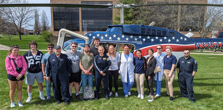 Nursing students group photo in front of helicopter