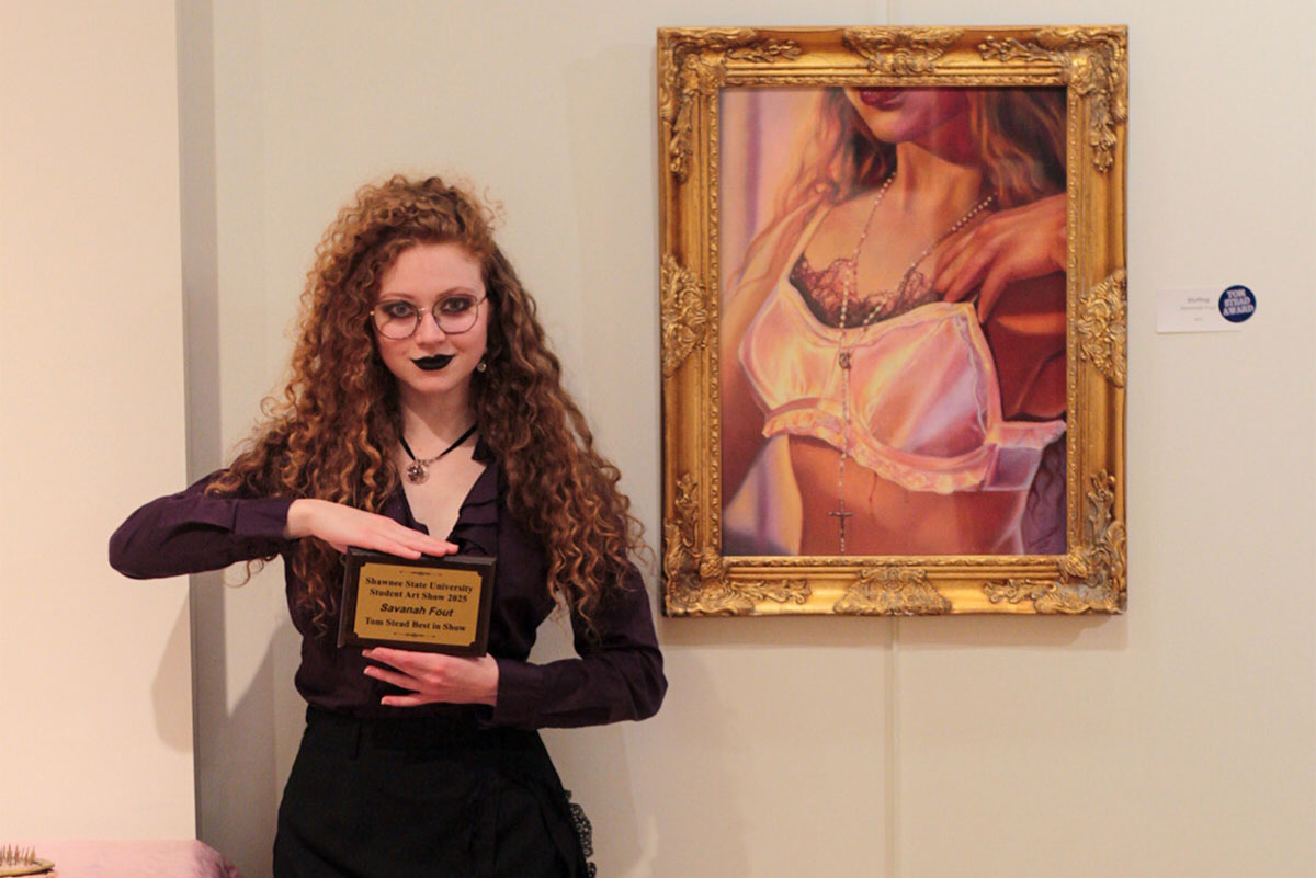 Savannah Fout posing with award and artwork