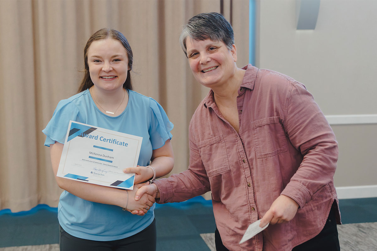 student receiving award from librarian