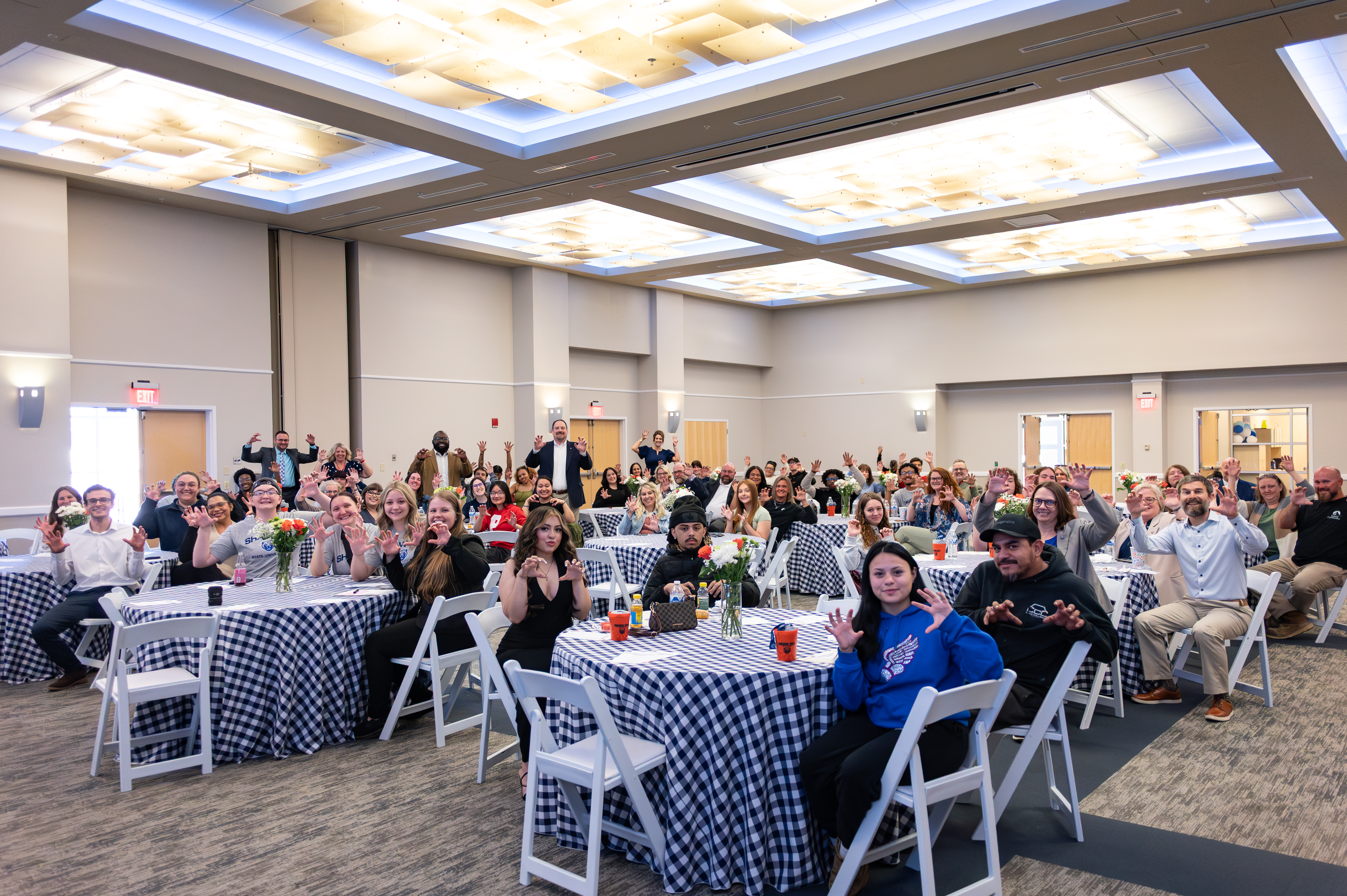 Group of people in ballroom doing Paws Up! motion