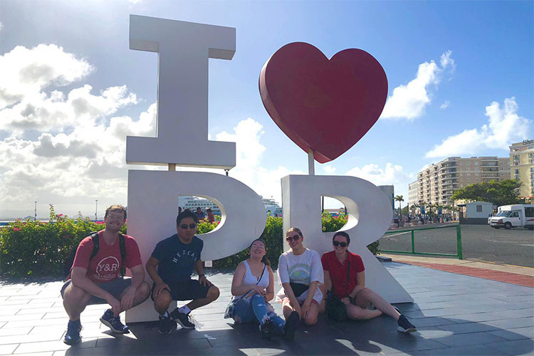 students posing in front of sign