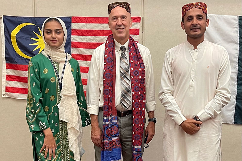 students posing in front of flags