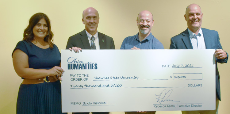 group of people holding large check