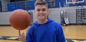 male student holding a basketball