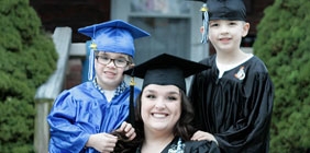 Woman with two boys in graduation regalia