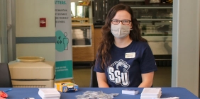 young woman sitting at convention booth