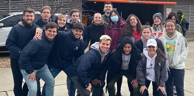 group of students posing in front of stadium