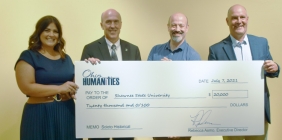 group of people holding large check