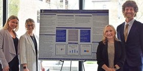 students posing with poster