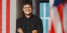 Man standing near American flags