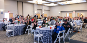 Group of people in ballroom doing Paws Up! motion